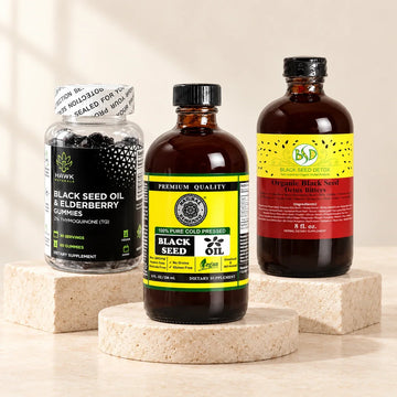 Black Seed Oil, Black Seed Detox Bitters, and Black Seed and Elderberry Gummies on ivory stone