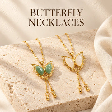 Butterfly Necklaces collection jewelry arranged on warm ivory stone at Ancient Infusions.