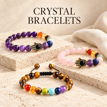Crystal Bracelets collection jewelry arranged on warm ivory stone at Ancient Infusions.