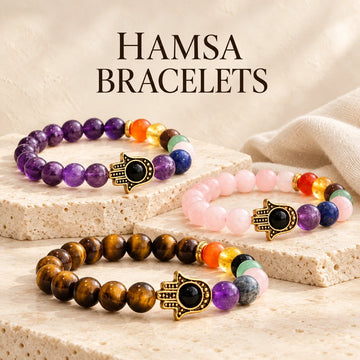 Hamsa Bracelets collection jewelry arranged on warm ivory stone at Ancient Infusions.
