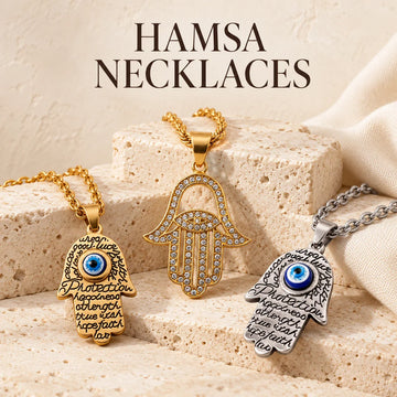 Hamsa Necklaces collection jewelry arranged on warm ivory stone at Ancient Infusions.