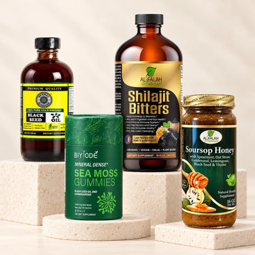 Black Seed Oil, Sea Moss Gummies, Shilajit Bitters, and Soursop Honey on ivory stone displays