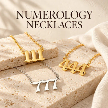 Numerology Necklaces collection jewelry arranged on warm ivory stone at Ancient Infusions.