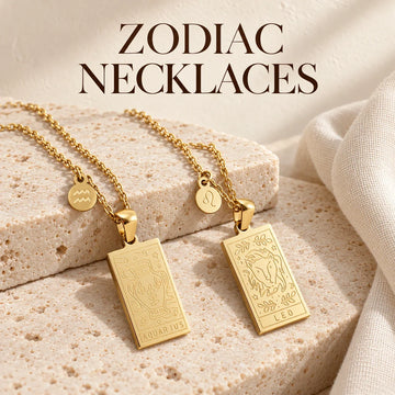 Zodiac Necklaces collection jewelry arranged on warm ivory stone at Ancient Infusions.