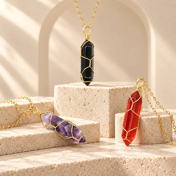 Hand-wired amethyst, obsidian, and carnelian crystal necklaces on ivory stone