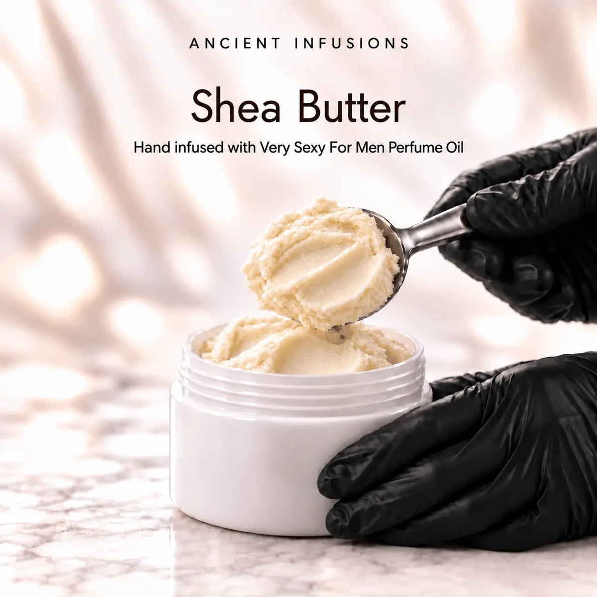Black vinyl-gloved hands scoop raw shea butter hand infused with Very Sexy For Men perfume oil.