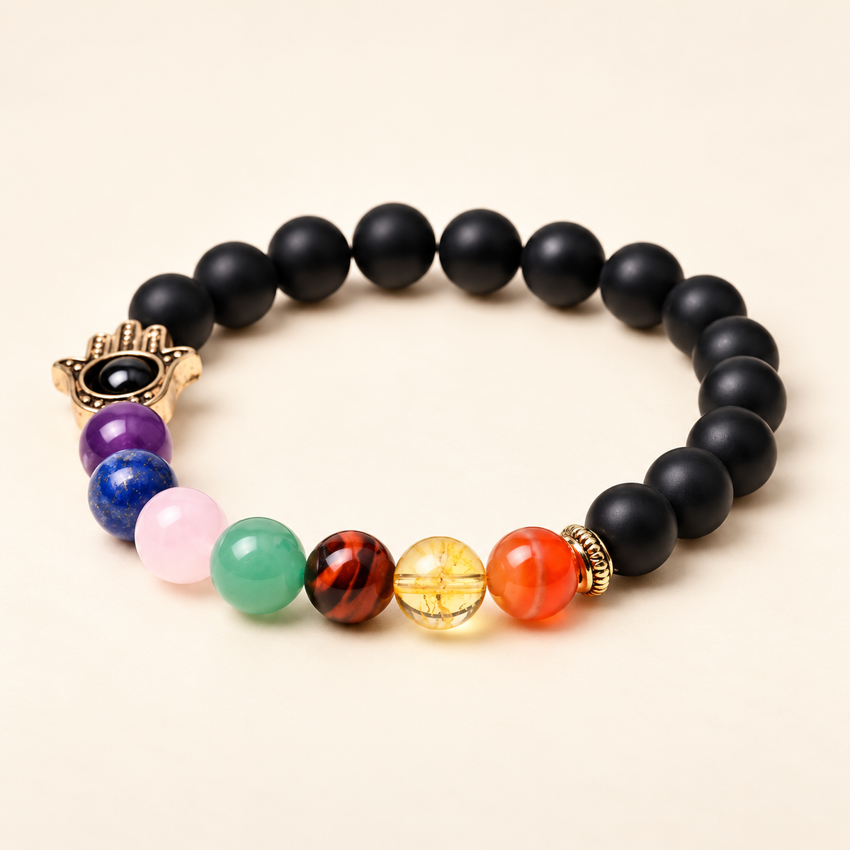 7 Chakra Black Onyx Hamsa Elastic Bracelet on a soft ivory background