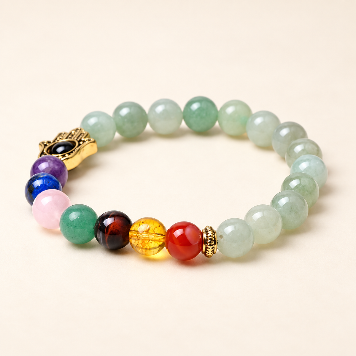 7 Chakra Green Aventurine Hamsa Elastic Bracelet on a soft ivory background