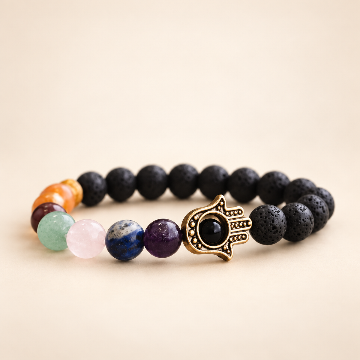 7 Chakra Lava Stone Hamsa Elastic Bracelet on a soft ivory background, view 1
