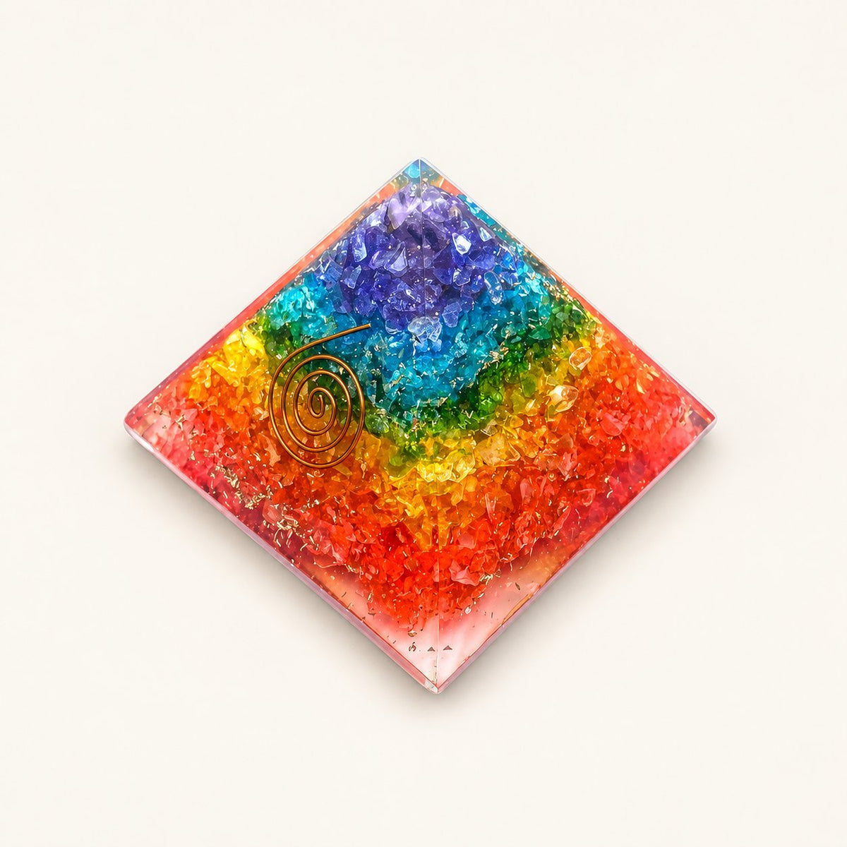 7 Chakra Orgone Pyramid – Rainbow with rainbow crystal layers and metallic details on a warm ivory background
