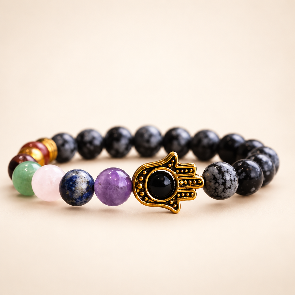 7 Chakra Snowflake Obsidian Hamsa Elastic Bracelet on a soft ivory background, view 1