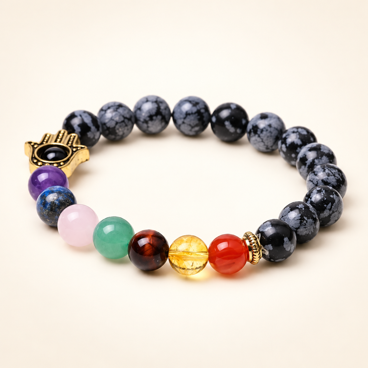 7 Chakra Snowflake Obsidian Hamsa Elastic Bracelet on a soft ivory background, view 2