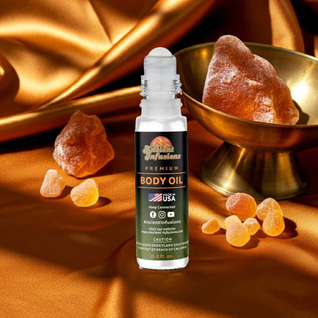 Amber Gold Body Oil roll-on with golden amber stones and luxurious silk background.