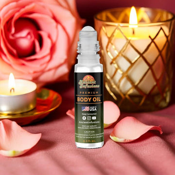 Amber Love body oil bottle with candles and roses on a pink background