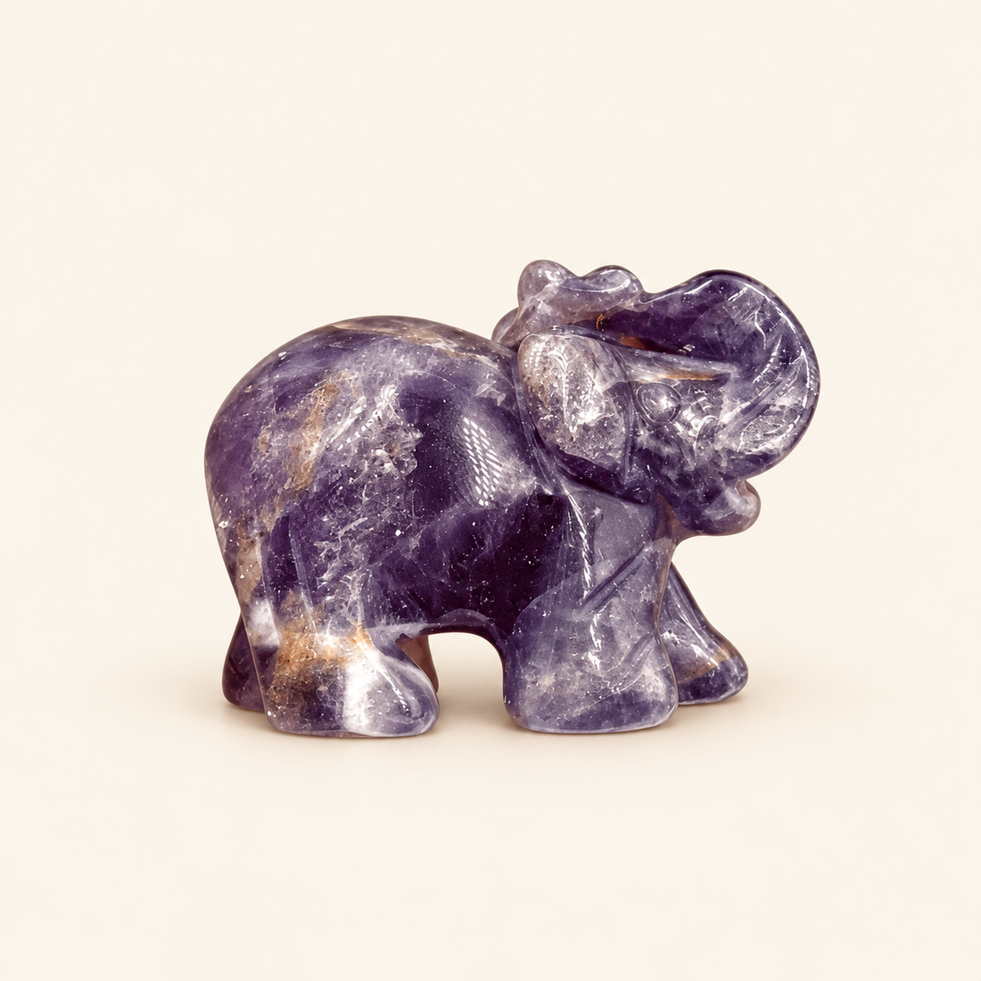 Amethyst Carved Elephant with rich purple tones on a soft ivory background