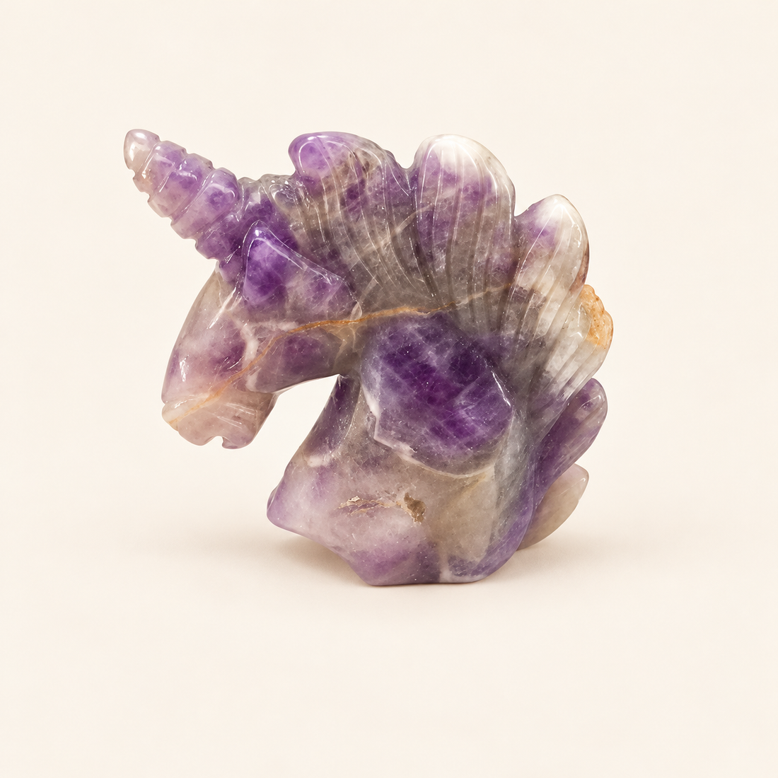 Amethyst Carved Unicorn with rich purple tones on a soft ivory background