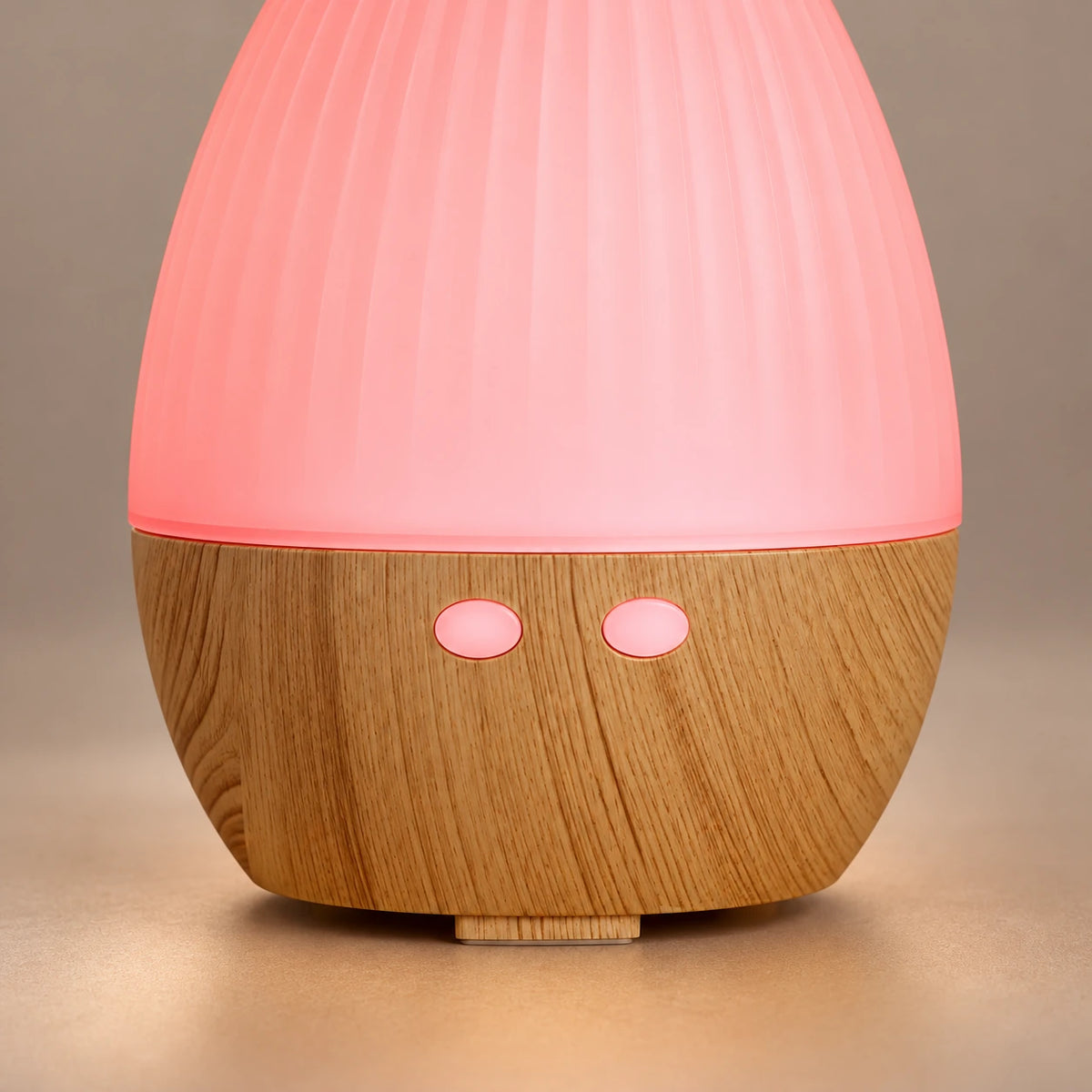 Teardrop diffuser showing two round pink buttons and the wood grain base.