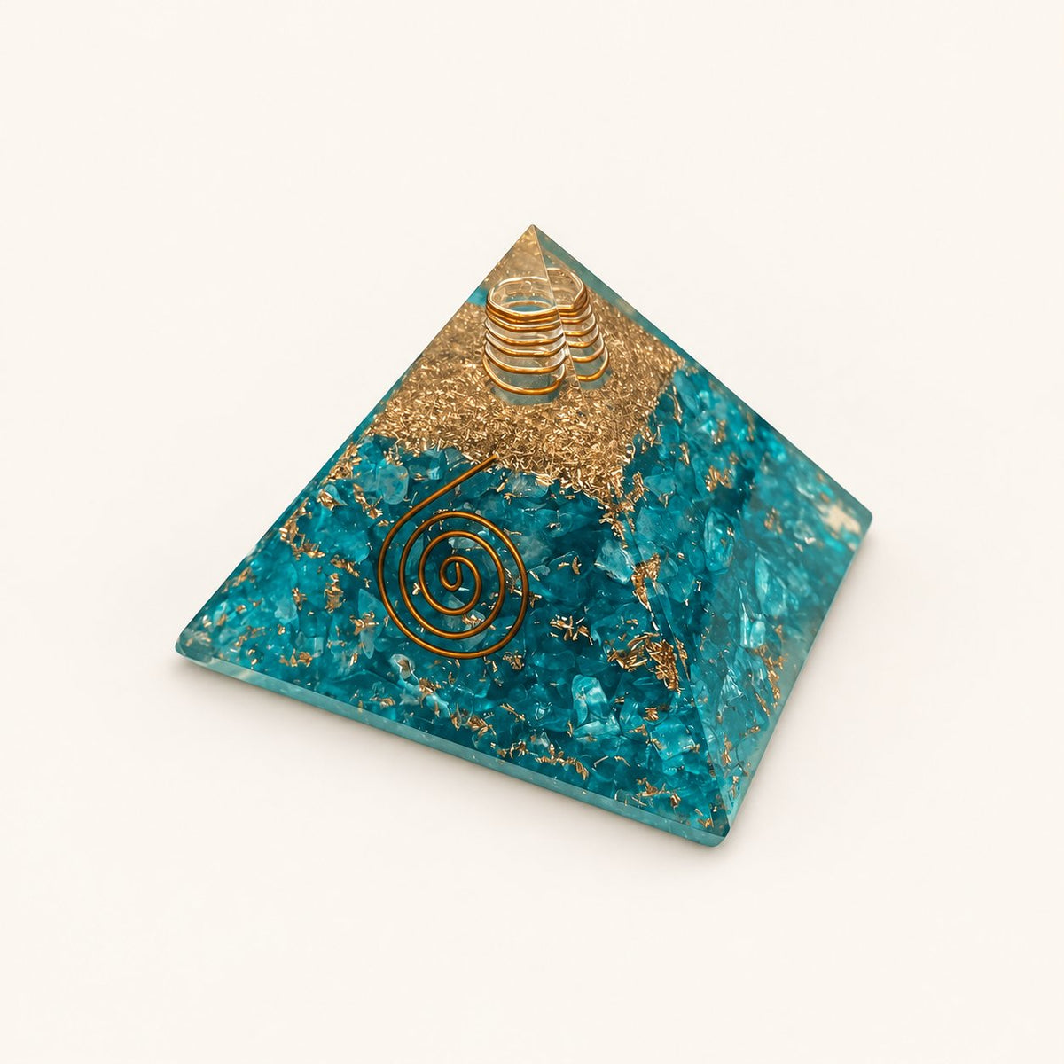 Aquamarine Orgone Pyramid with aqua-blue aquamarine chips and metallic details on a warm ivory background
