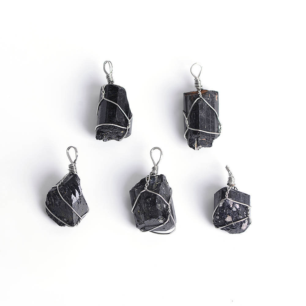 Close-up of a Black Tourmaline Necklace featuring a polished black gemstone wrapped in handcrafted gold wire with a stainless steel chain.