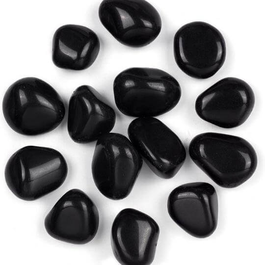 Natural Black Obsidian tumbled stones showcasing their glossy finish and powerful healing properties.
