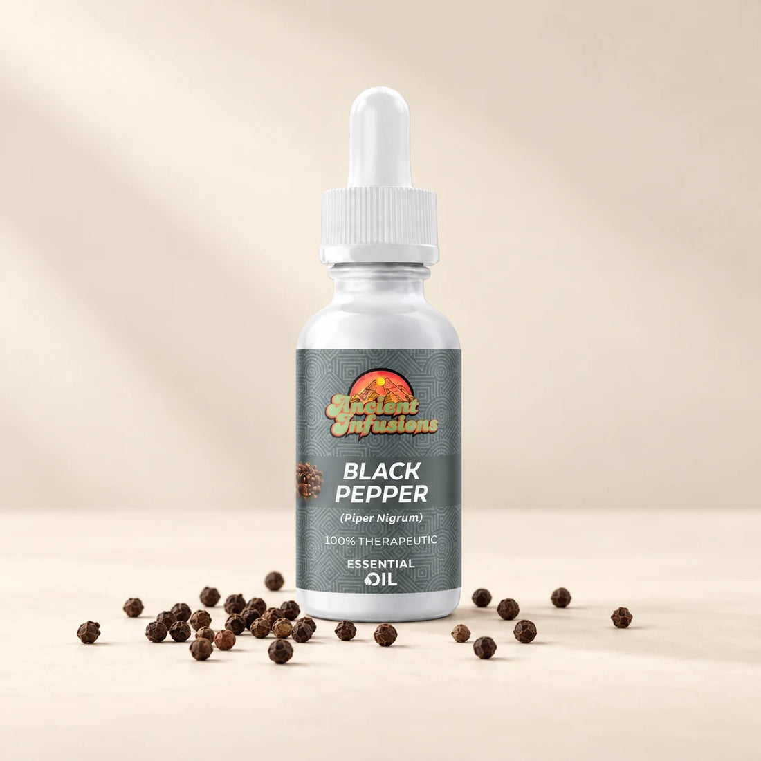 Ancient Infusions Black Pepper Essential Oil bottle with botanicals on a soft ivory background.