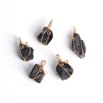 Close-up of a Black Tourmaline Necklace featuring a polished black gemstone wrapped in handcrafted gold wire with a stainless steel chain.