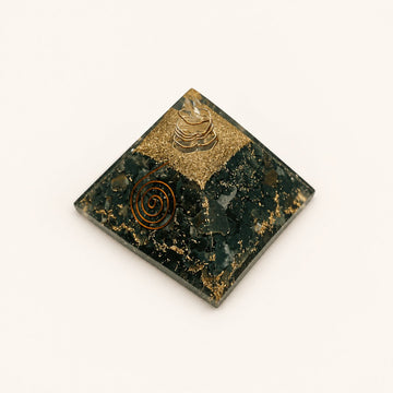 Bloodstone Orgone Pyramid with deep green bloodstone chips and metallic details on a warm ivory background