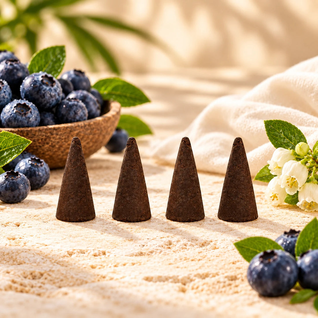 Blueberry incense cones surrounded by blueberries.