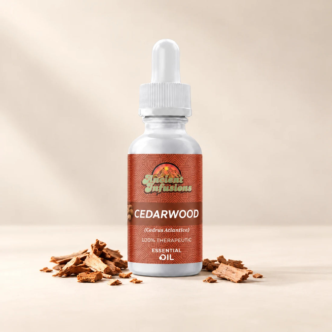 Ancient Infusions Cedarwood Atlas Essential Oil bottle with botanicals on a soft ivory background.