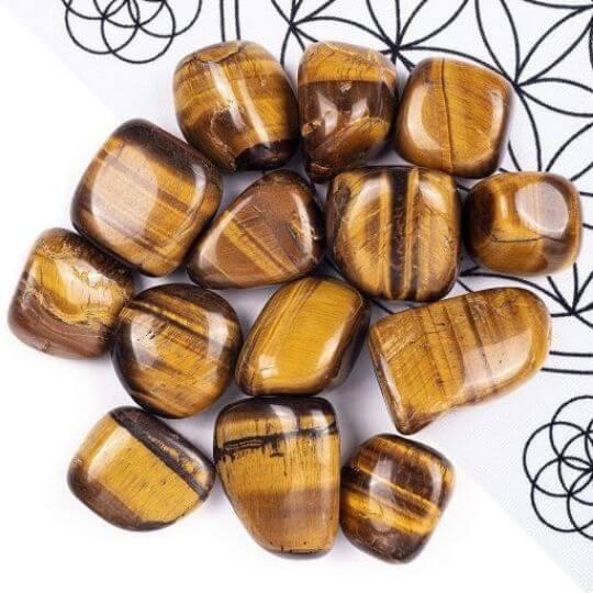 Polished Tiger’s Eye tumbled stones showcasing their golden hues, healing properties, and grounding benefits.