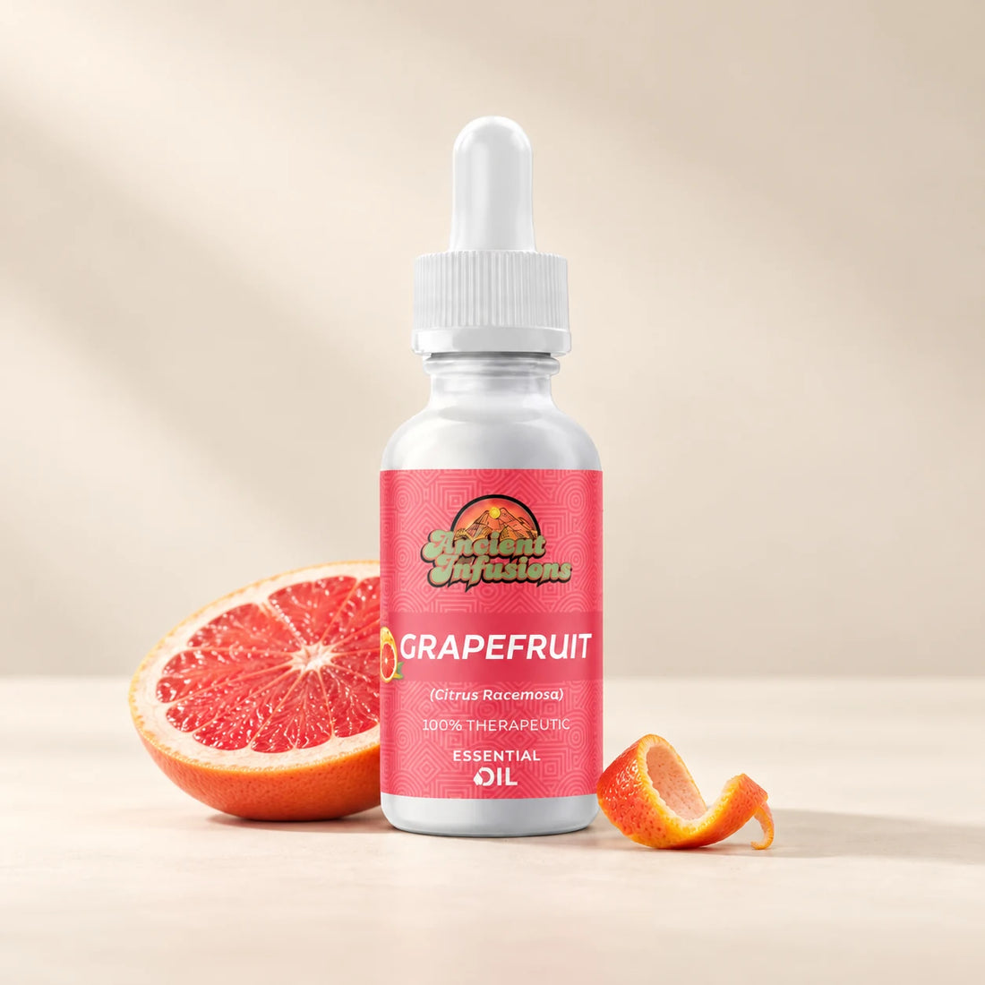 Ancient Infusions Grapefruit Essential Oil bottle with botanicals on a soft ivory background.