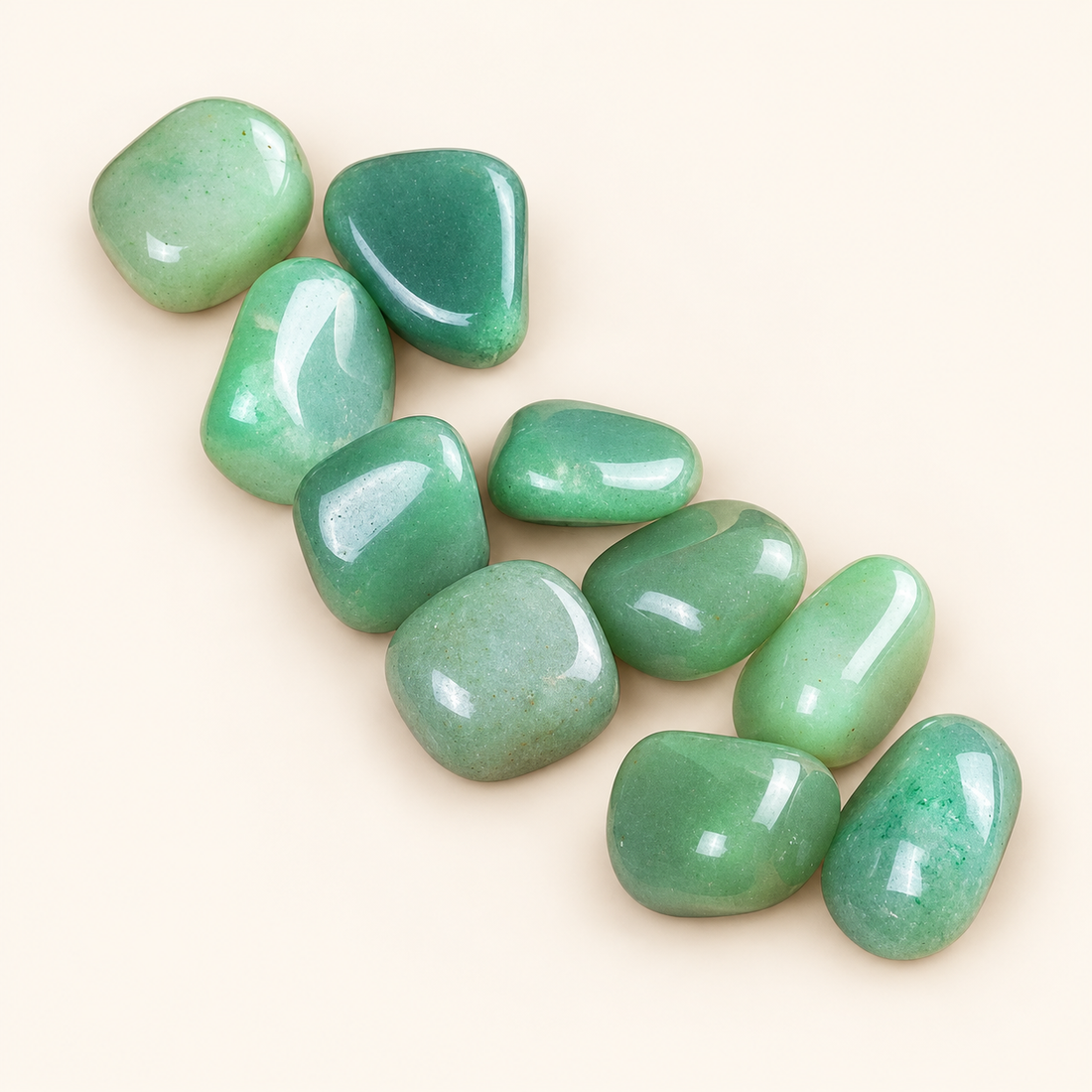 Green Aventurine tumbled stones with soft green tones on a soft ivory background