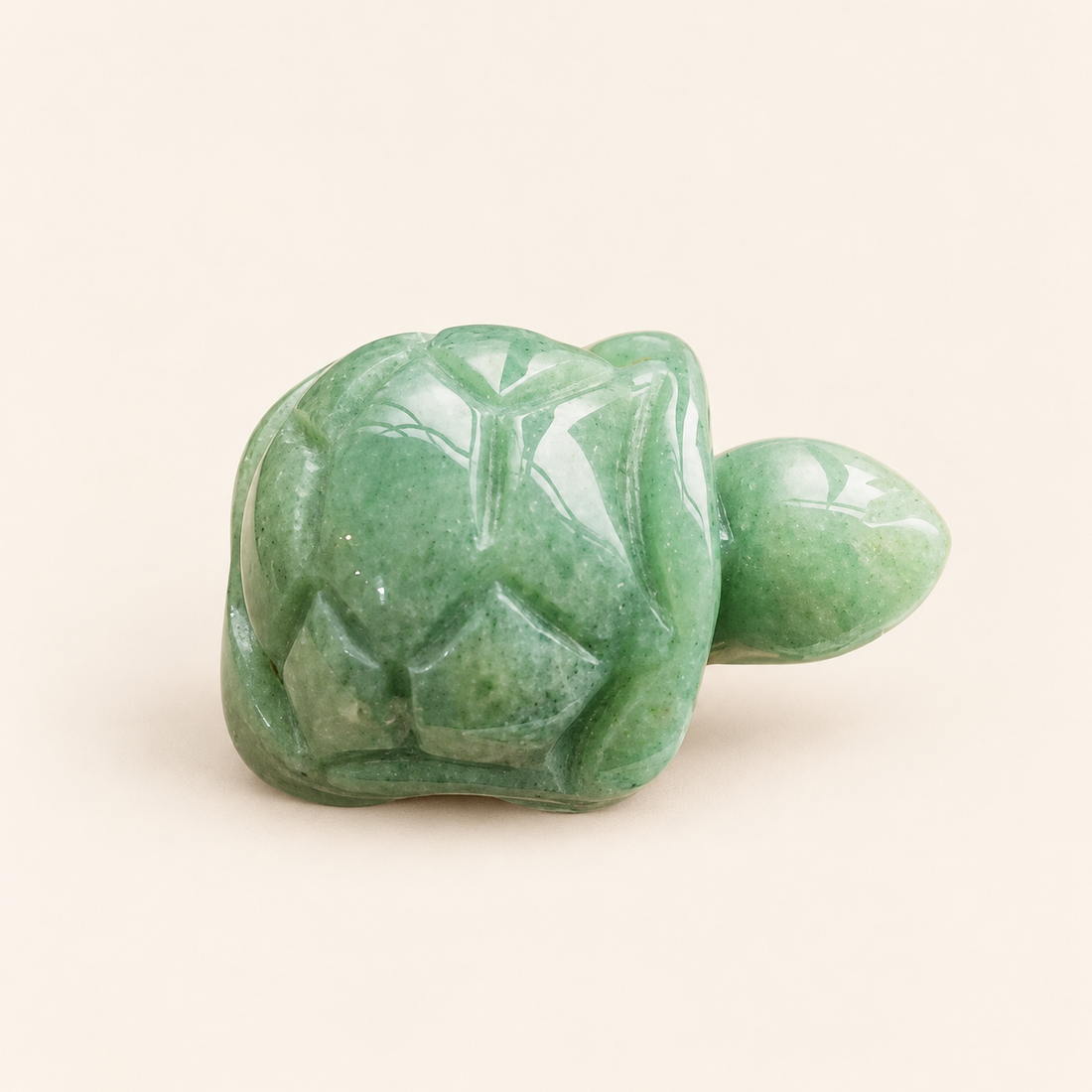 Green Aventurine Carved Turtle with soft green tones on a soft ivory background