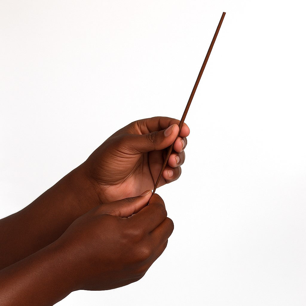 a hand holding Wintergreen Incense Sticks in front of a white background