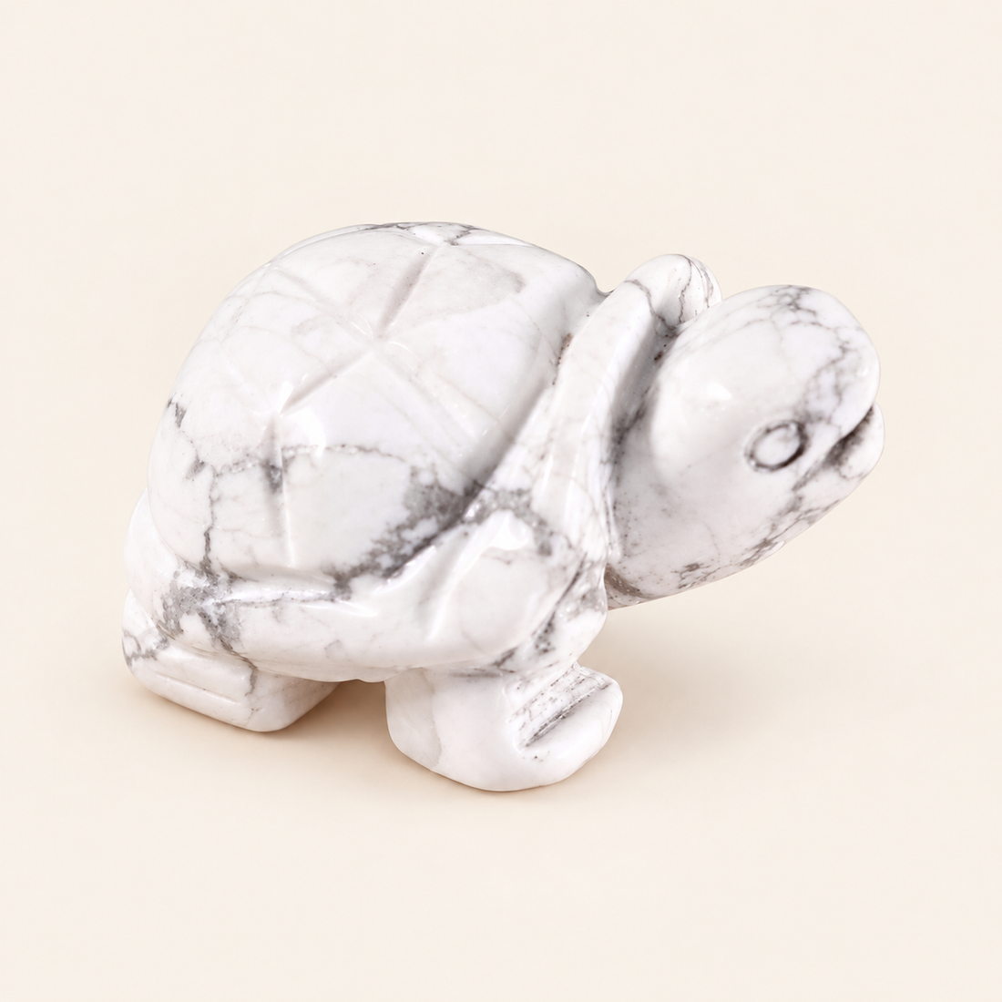 Howlite Carved Turtle with white tones with gray veining on a soft ivory background