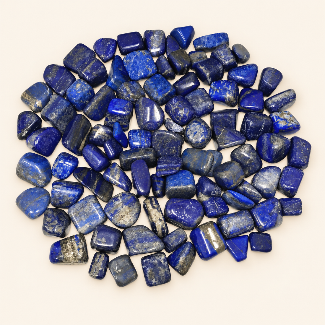 Lapis Lazuli tumbled stones with deep blue tones on a soft ivory background
