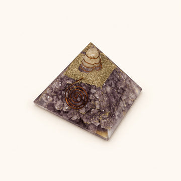 Lepidolite Orgone Pyramid with soft lilac lepidolite chips and metallic details on a warm ivory background