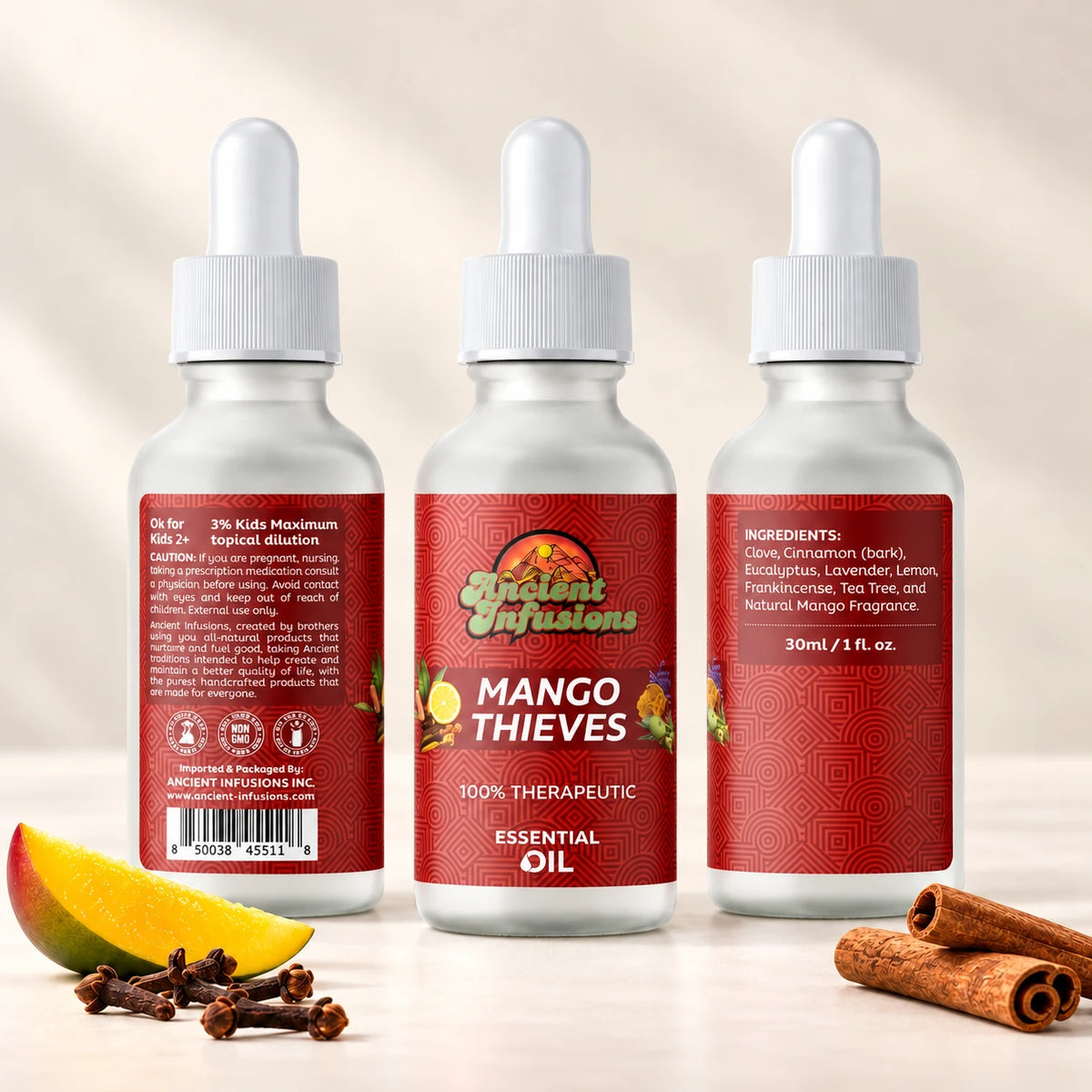 Ancient Infusions Mango Thieves Essential Oil Blend shown in three bottle views with front, caution and ingredient labels on a soft ivory background with mango, cinnamon and cloves.