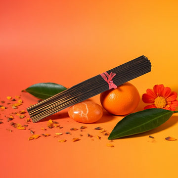 Orange Incense Sticks with orange fruits and leaves on a gradient background