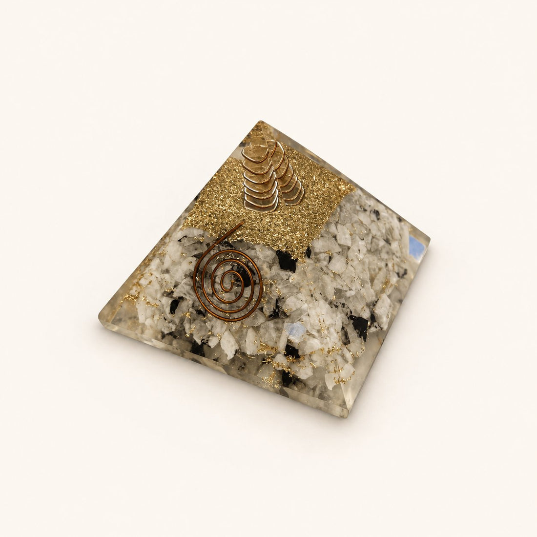 Rainbow Moonstone Orgone Pyramid with pale rainbow moonstone chips with dark accents and metallic details on a warm ivory background