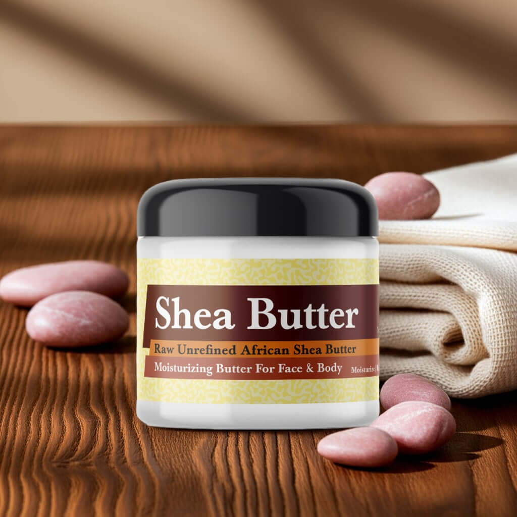Amber Love Scented Shea Butter jar on wooden table with smooth stones and towel.