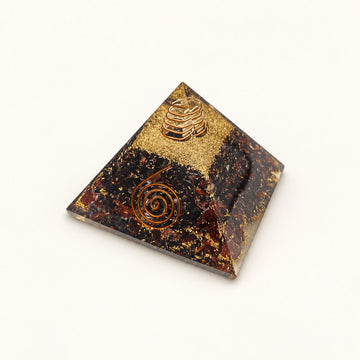Red Garnet Orgone Pyramid with deep wine-red garnet chips and metallic details on a warm ivory background