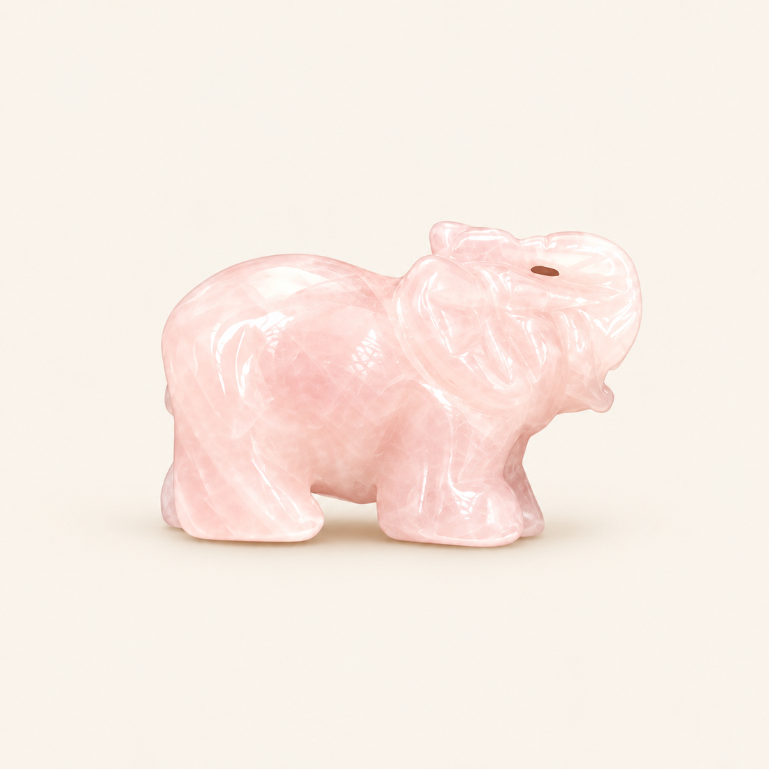 Rose Quartz Carved Elephant with soft pink tones on a soft ivory background