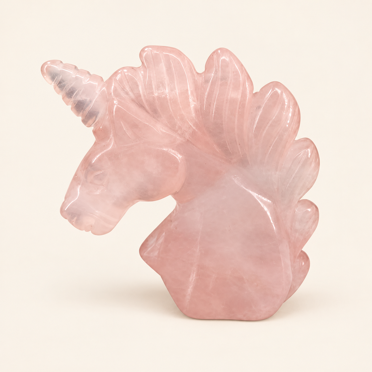Rose Quartz Carved Unicorn with soft pink tones on a soft ivory background