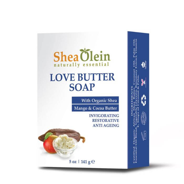 Shea Olein Love Butter Soap with cocoa pods, mango, and shea butter on a white bathroom counter – hydrating and anti-aging body bar.
