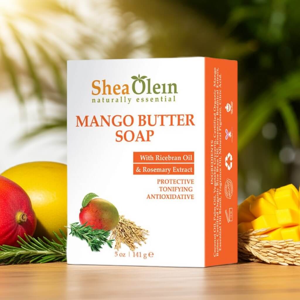 Shea Olein Mango Butter Soap with upright box, mango, rosemary, and rice bran on wood counter – antioxidant and toning bar for daily skin care.