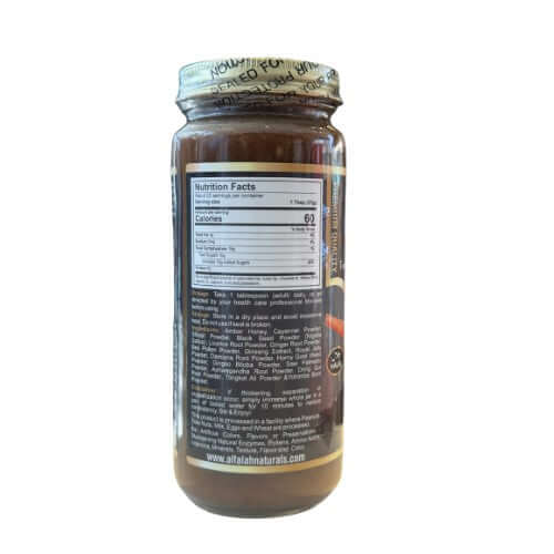 Angled view of Shilajit Herbal Honey 16 oz. jar surrounded by fresh ingredients