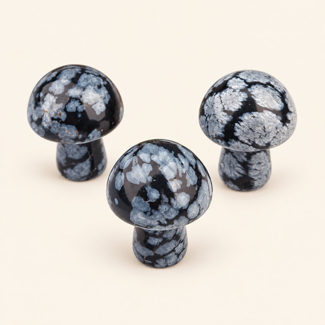 Snowflake Obsidian Carved Mushroom with black tones with pale speckling on a soft ivory background
