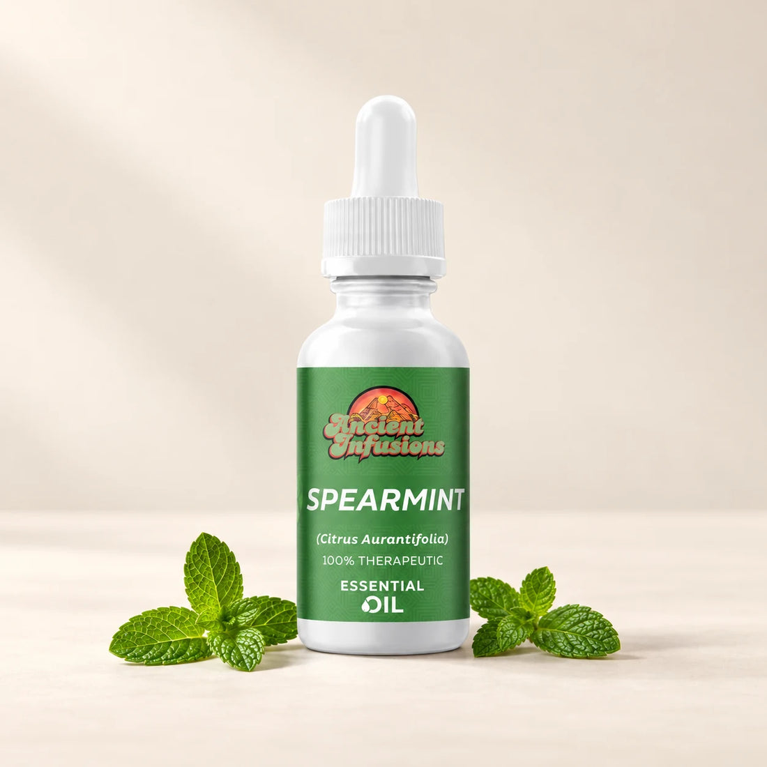 Ancient Infusions Spearmint Essential Oil bottle with botanicals on a soft ivory background.