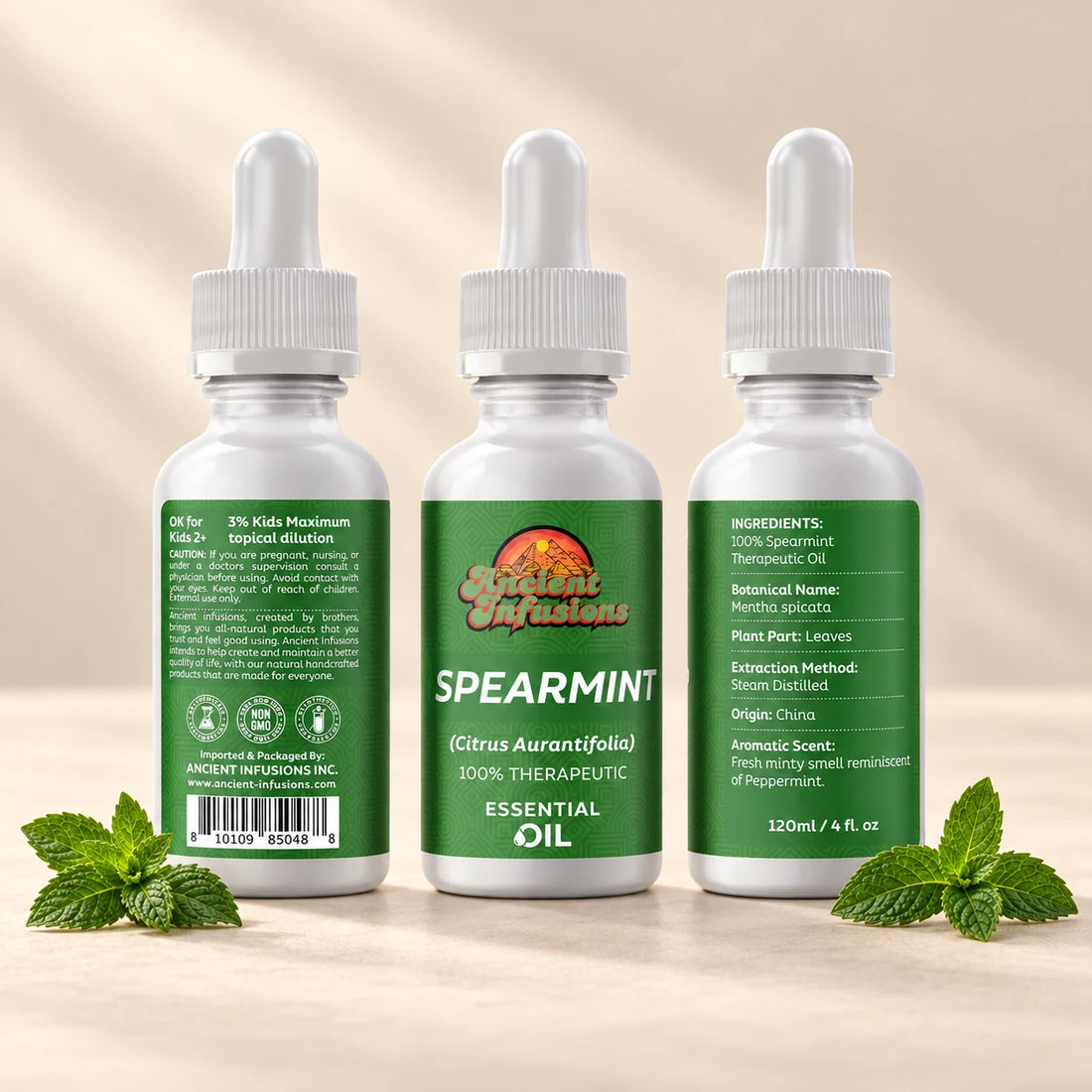 Ancient Infusions Spearmint Essential Oil bottle with botanicals on a soft ivory background.